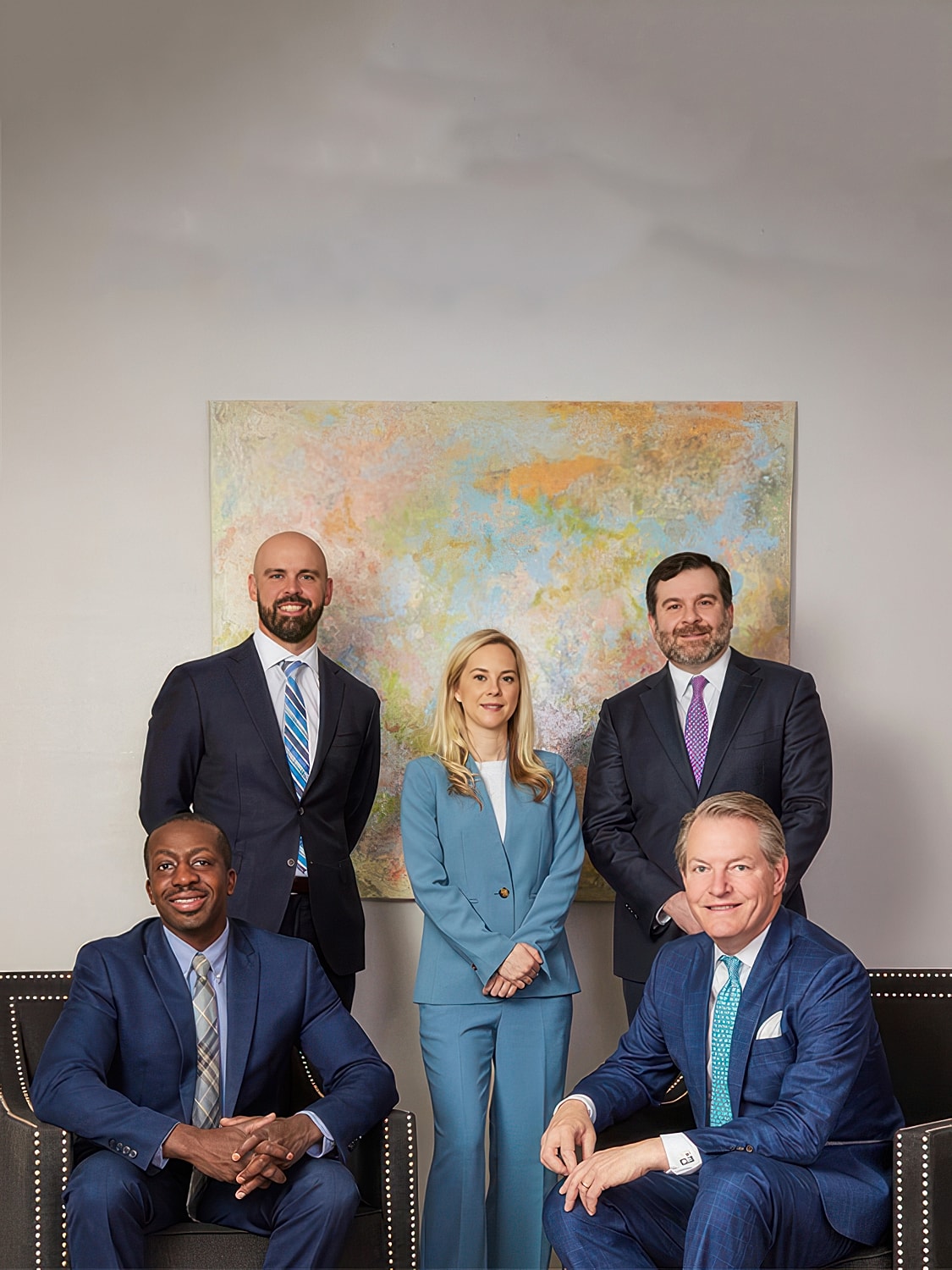 Man in blazer sitting thoughtfully, black and white.