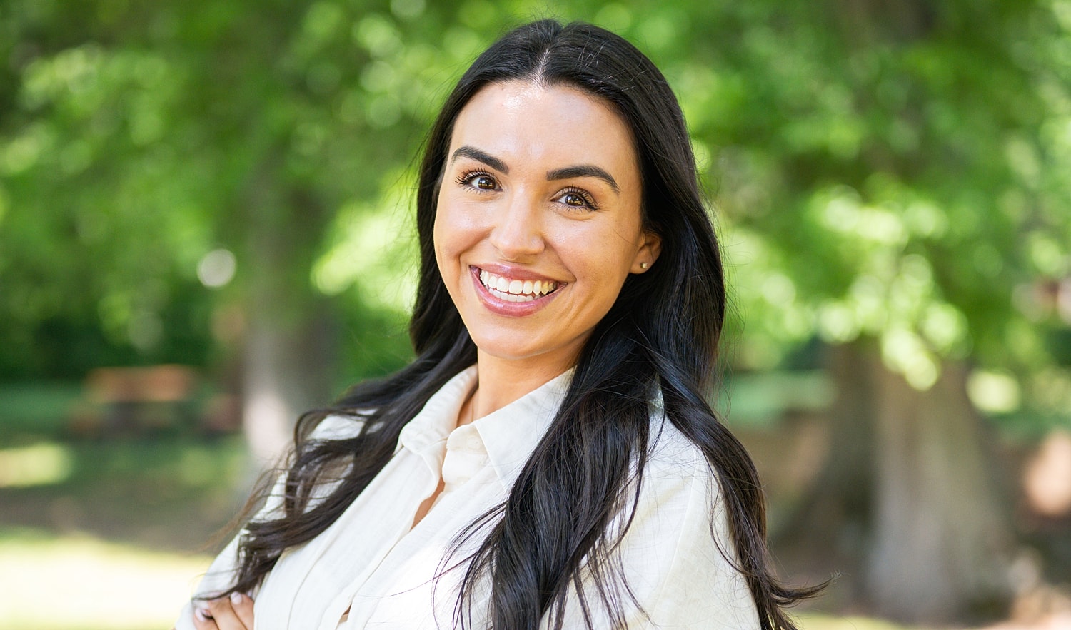 Smiling woman in a park setting.
