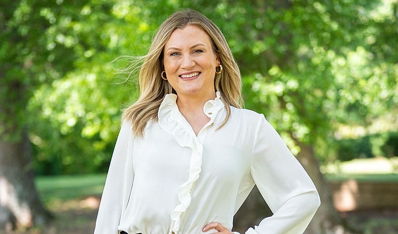 Smiling woman in a park setting.