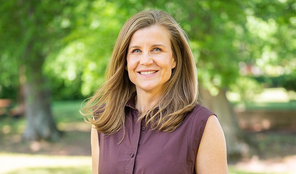 Smiling woman outdoors with long hair.