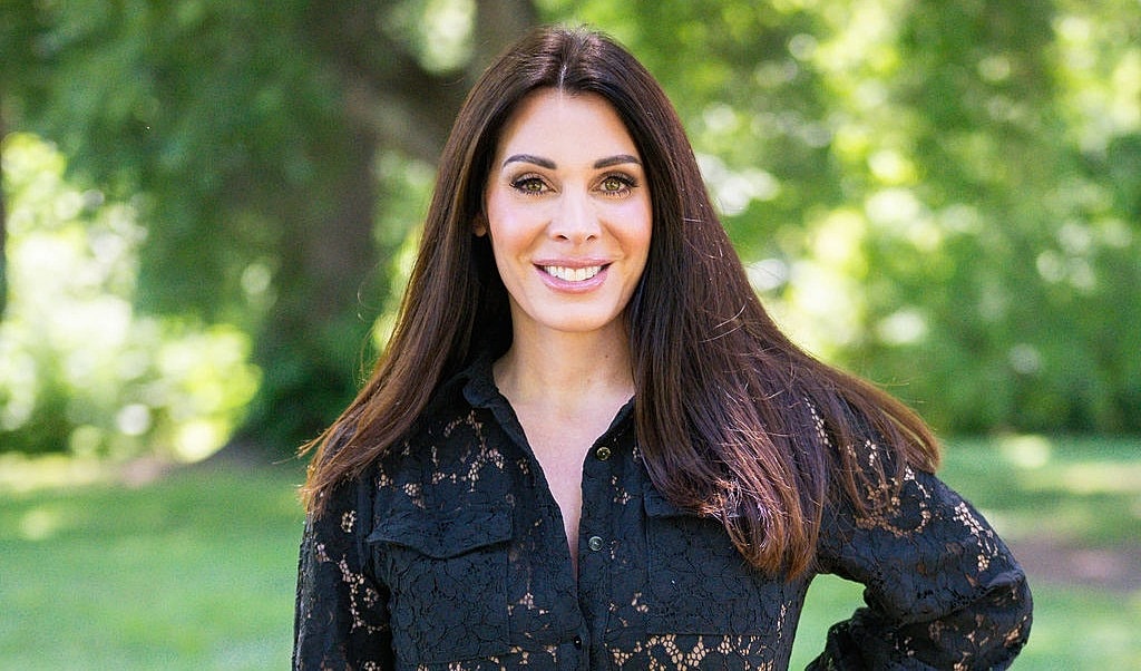 Woman smiling in a park, wearing black lace.