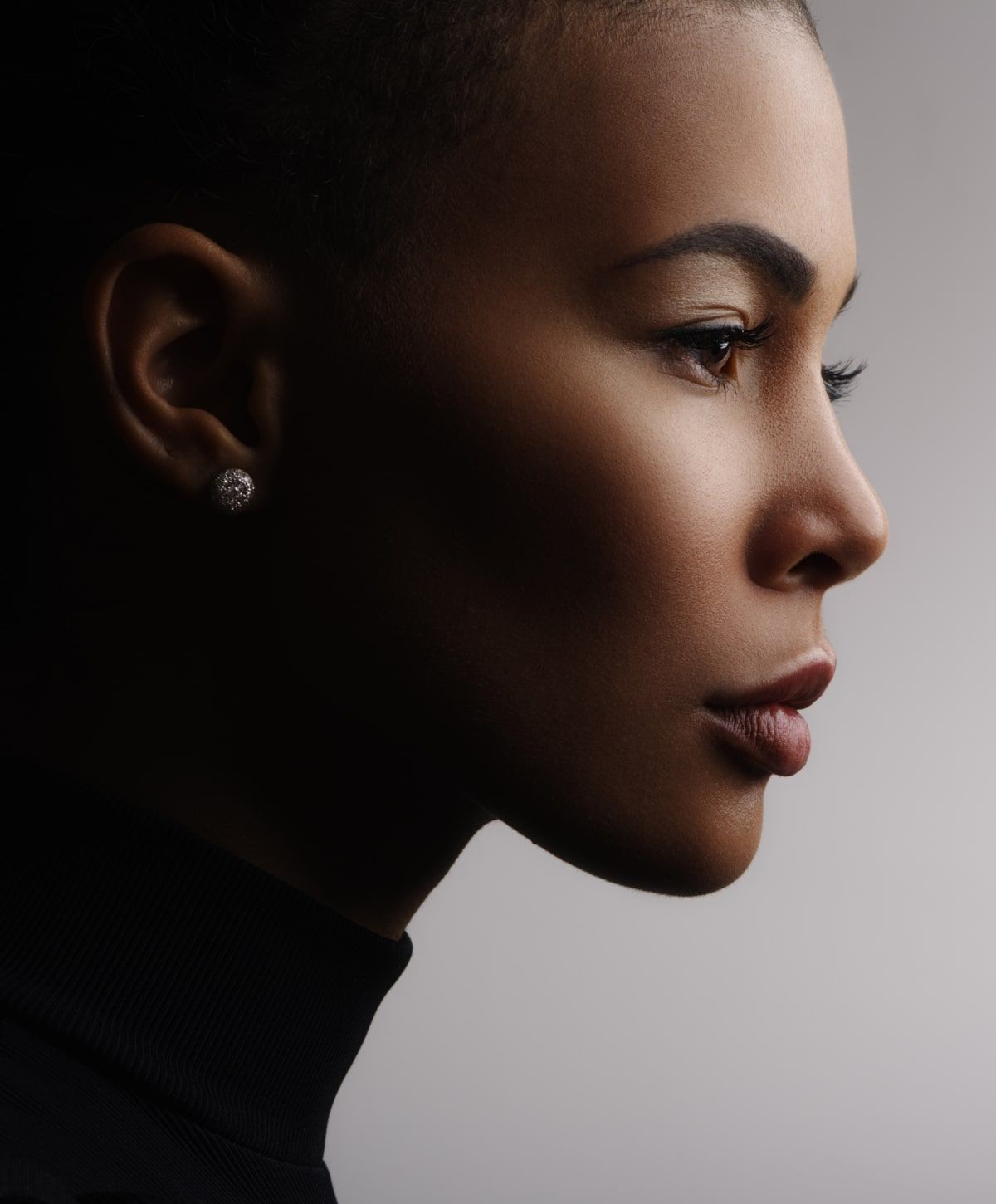 Profile portrait of a woman in soft lighting.