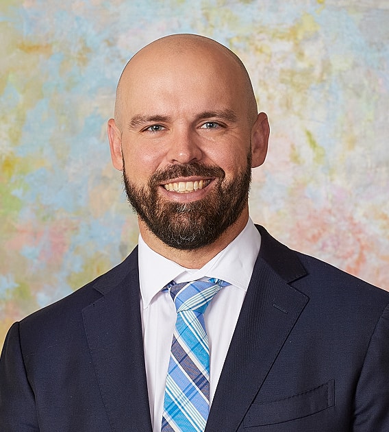 Smiling man in a suit with beard.