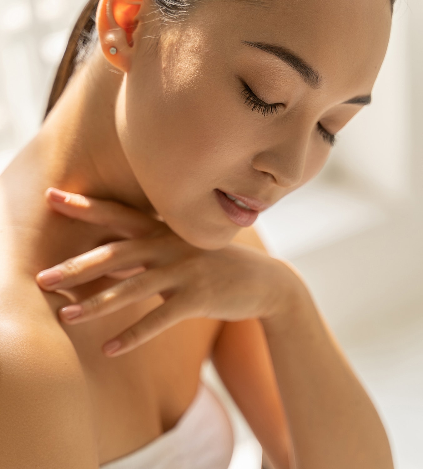 Close-up of a serene woman touching her neck.