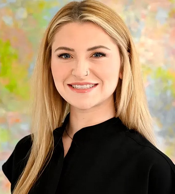Smiling woman with long hair in black shirt.