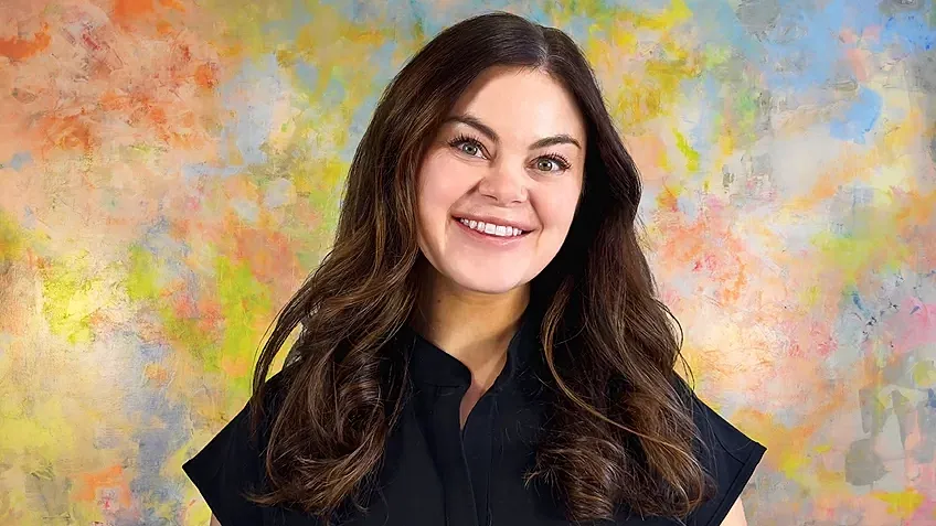 Smiling woman against a colorful background.