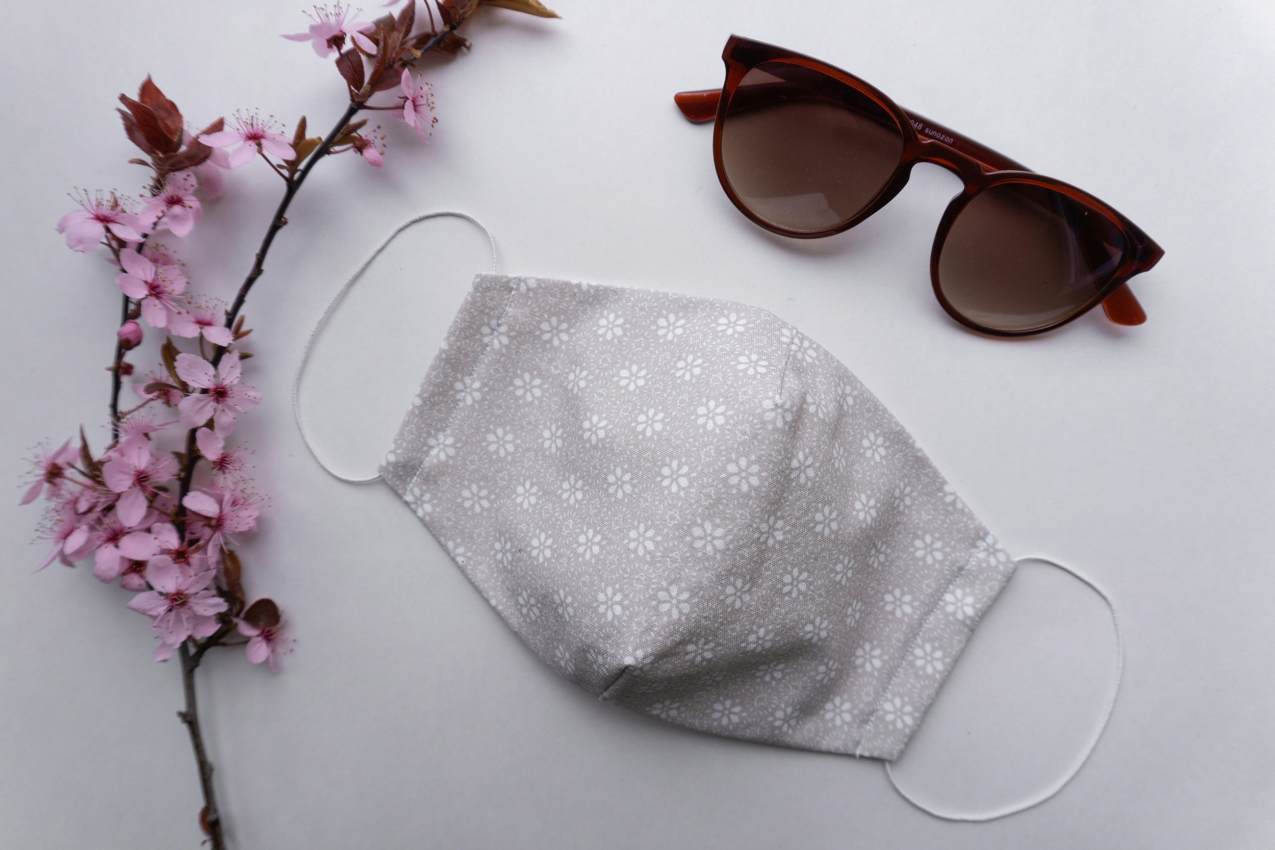Face mask, sunglasses, and cherry blossom branch.
