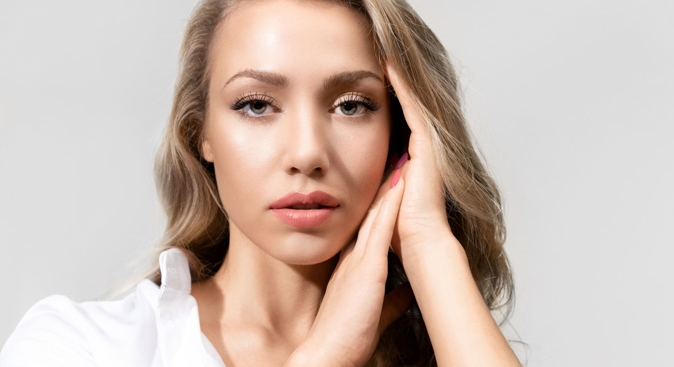 Close-up of woman with long hair and thoughtful expression.