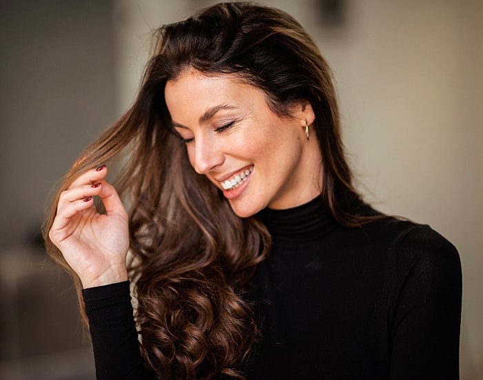 Smiling woman with long, wavy hair.